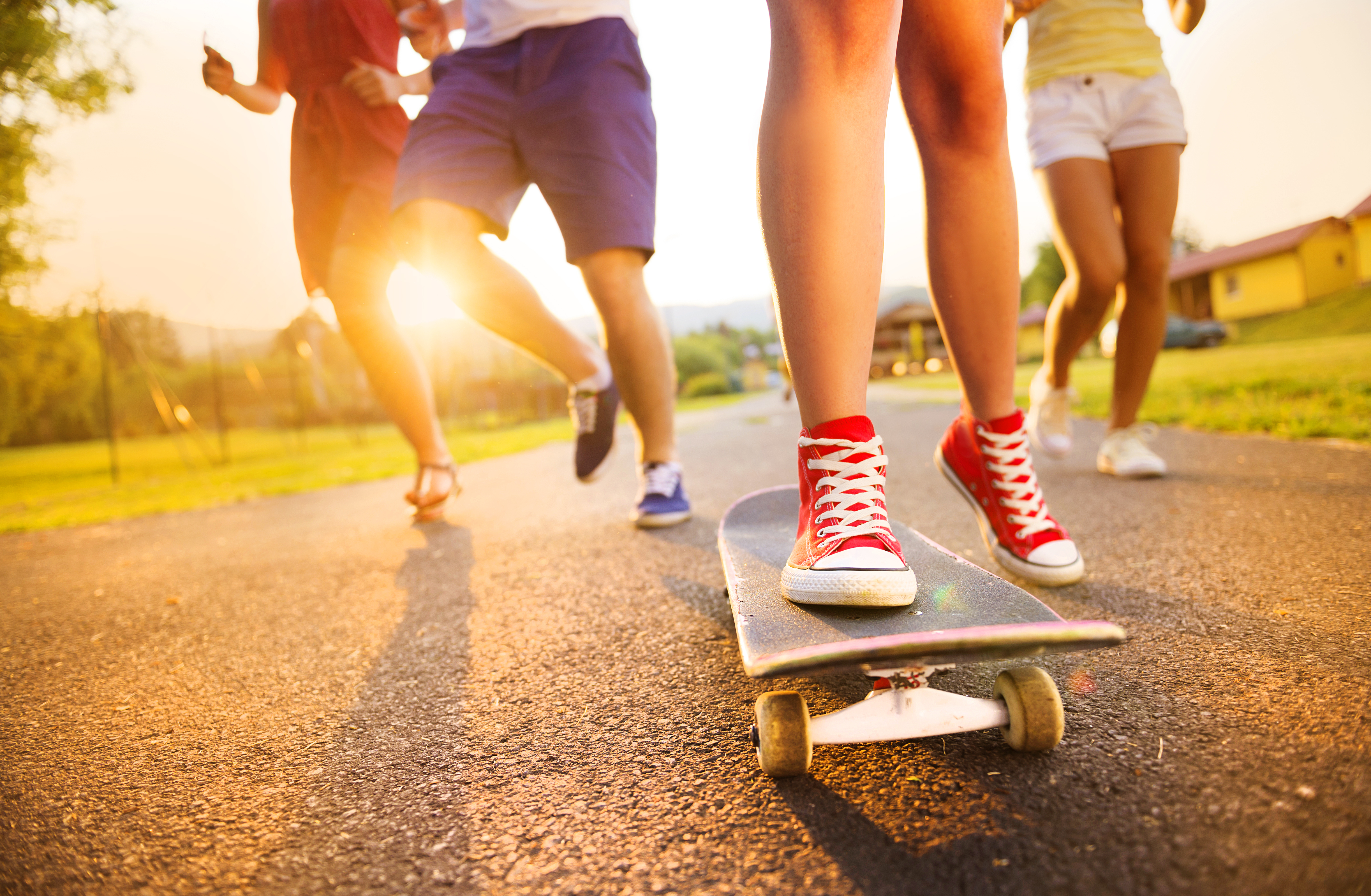 Jugendliche, die mit einem Skateboard unterwegs sind.