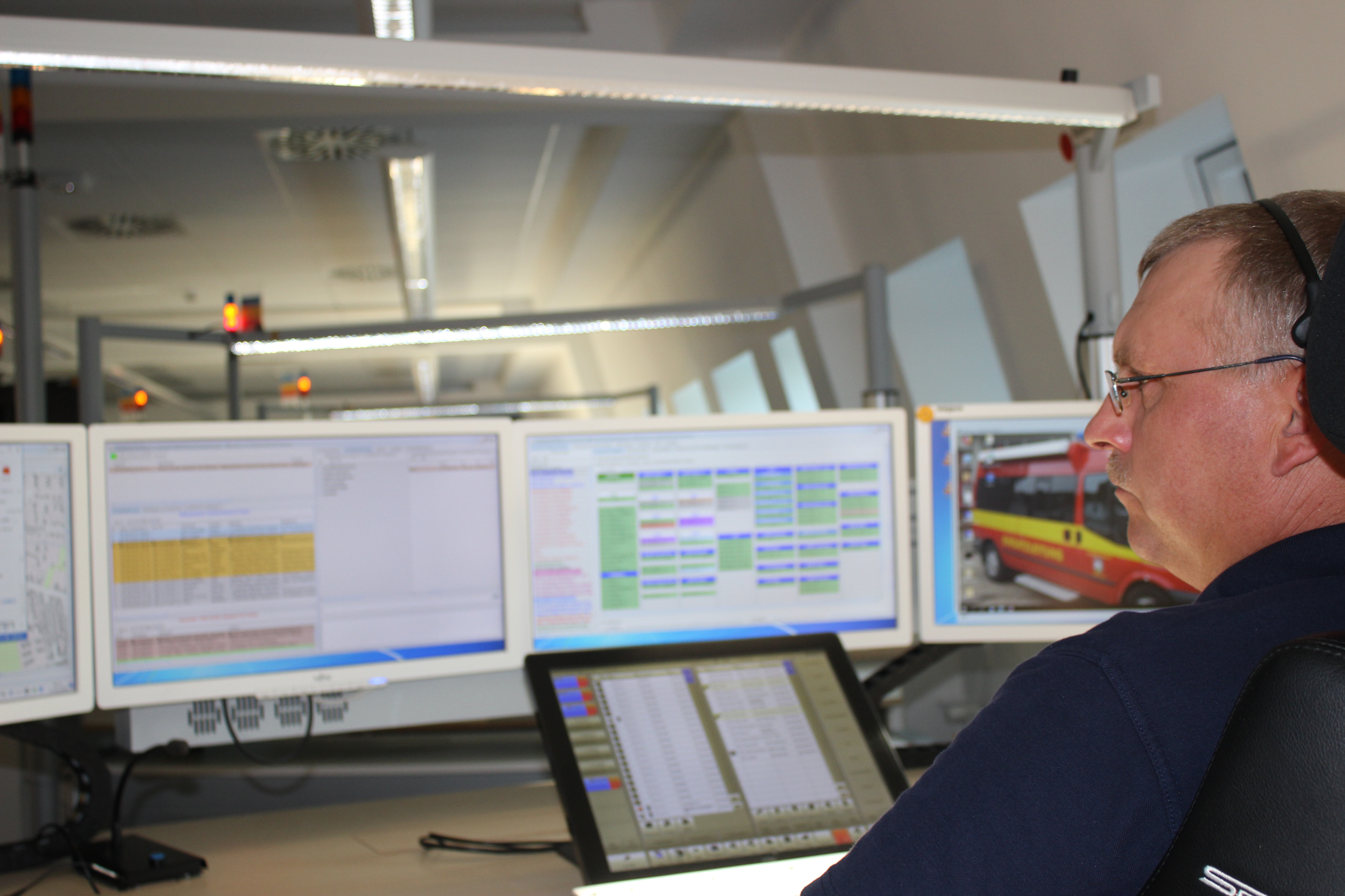 Die Leitstelle des Landkreises Lüneburg. Ein Mann sitzt vor verschiedenen Computermonitoren.