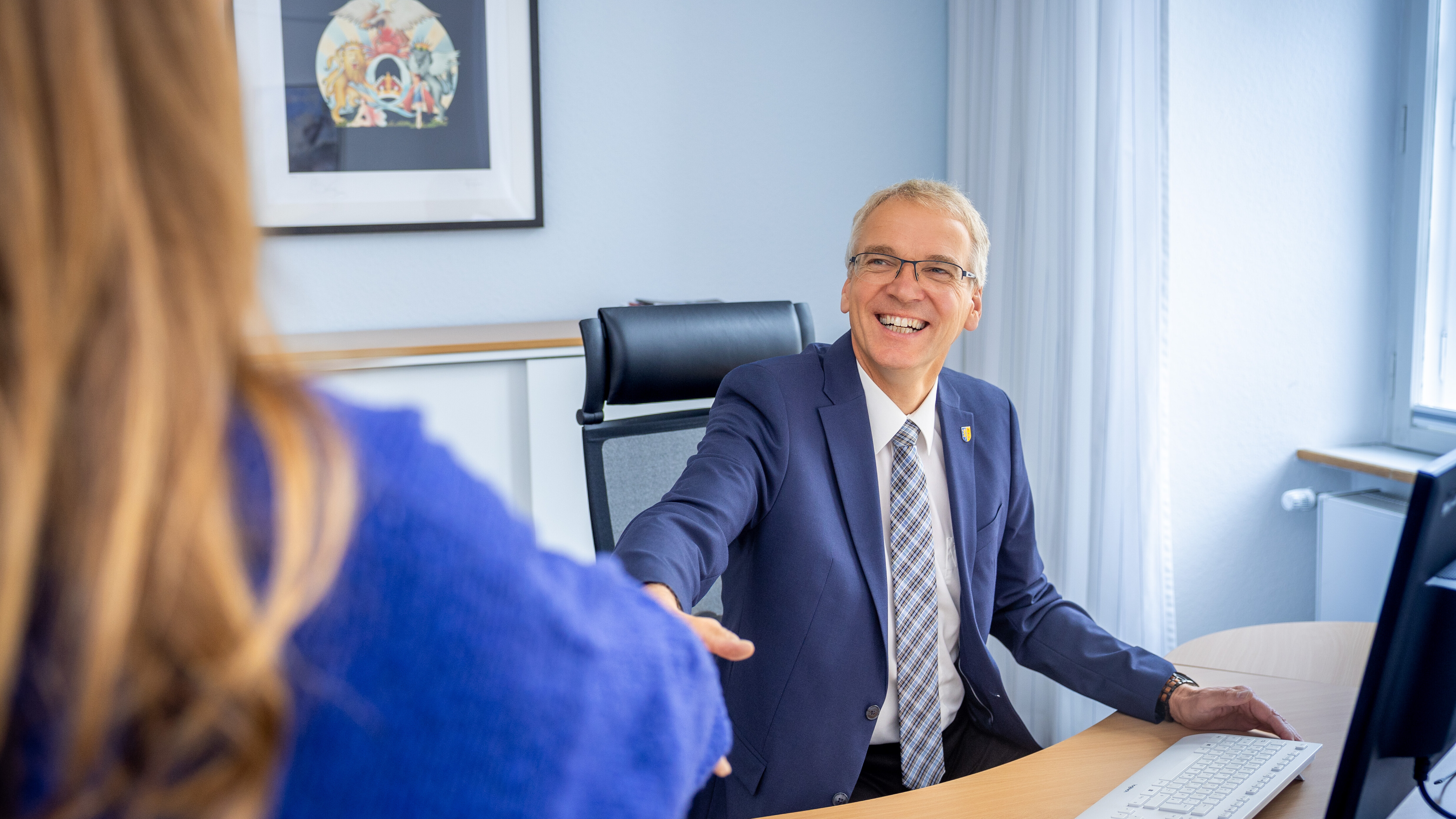 Landrat Jens Böther sitzt an einem Schreibtisch und gestikuliert erklärend in einer Gesprächssituation.