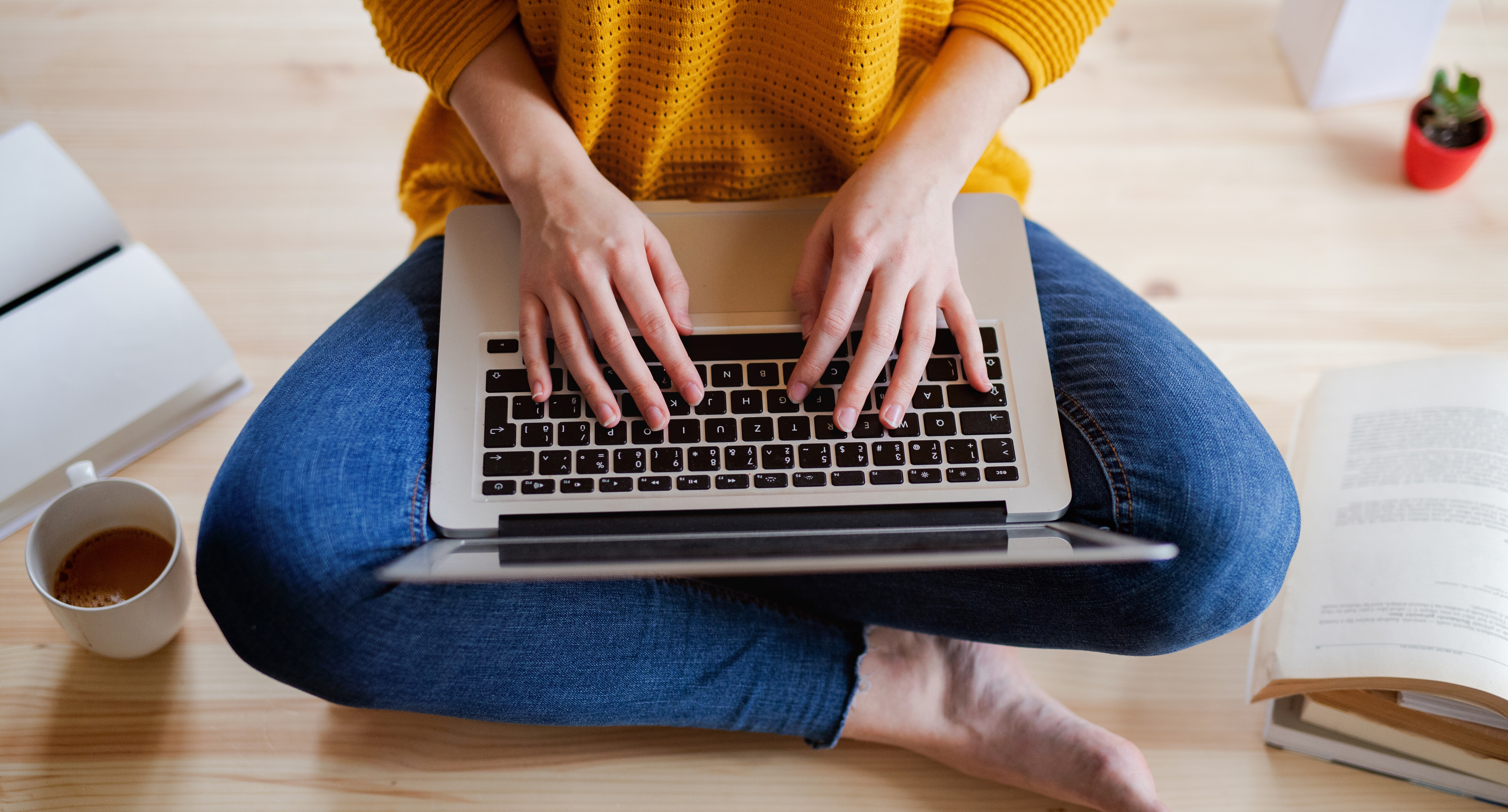 Frau tippt mit allen zehn Fingern auf ihrer Laptoptastatur die Tasten.