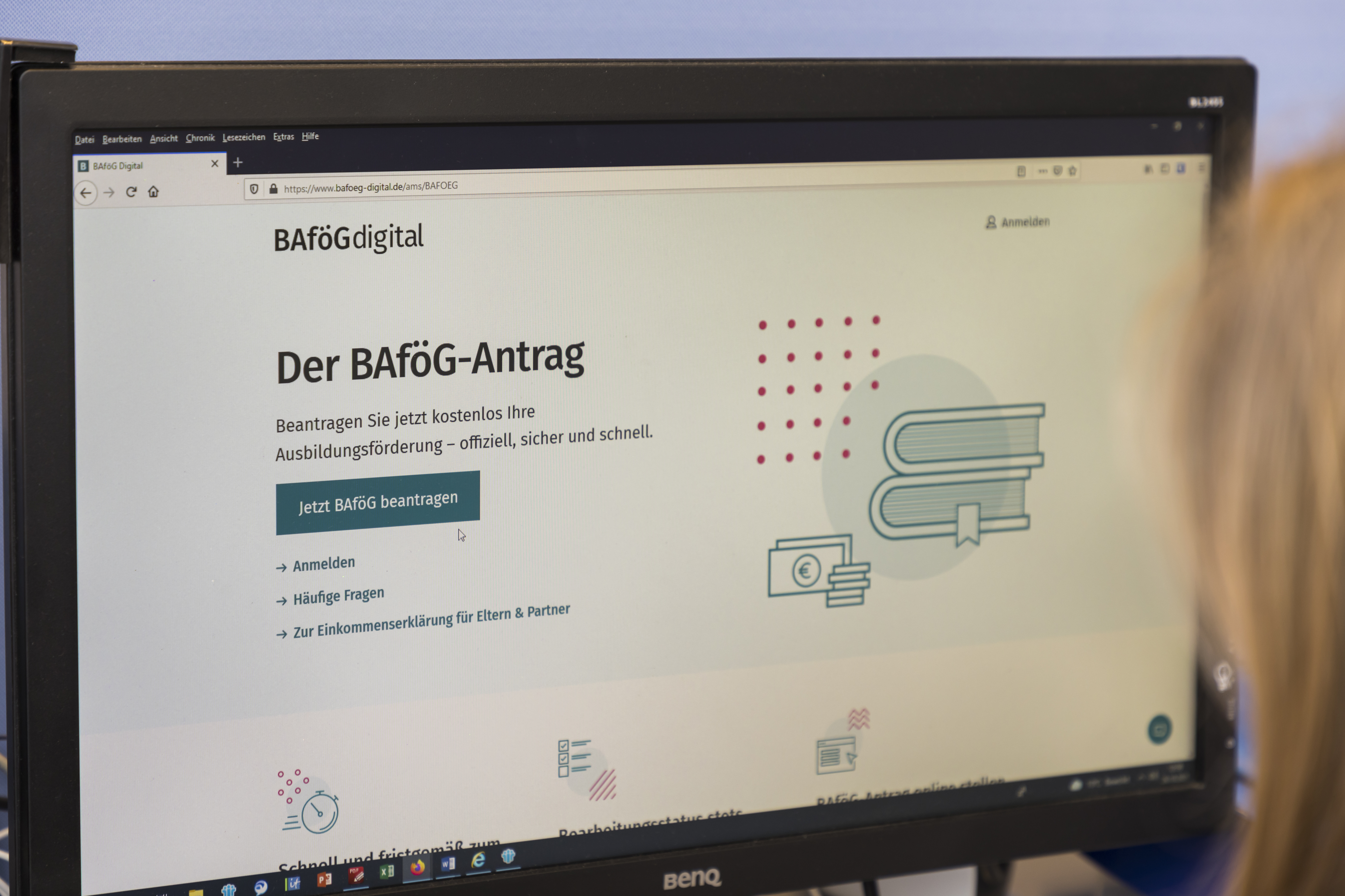 Eine Frau sitzt vor einem Computerbildschirm und beantragt online BAföG.