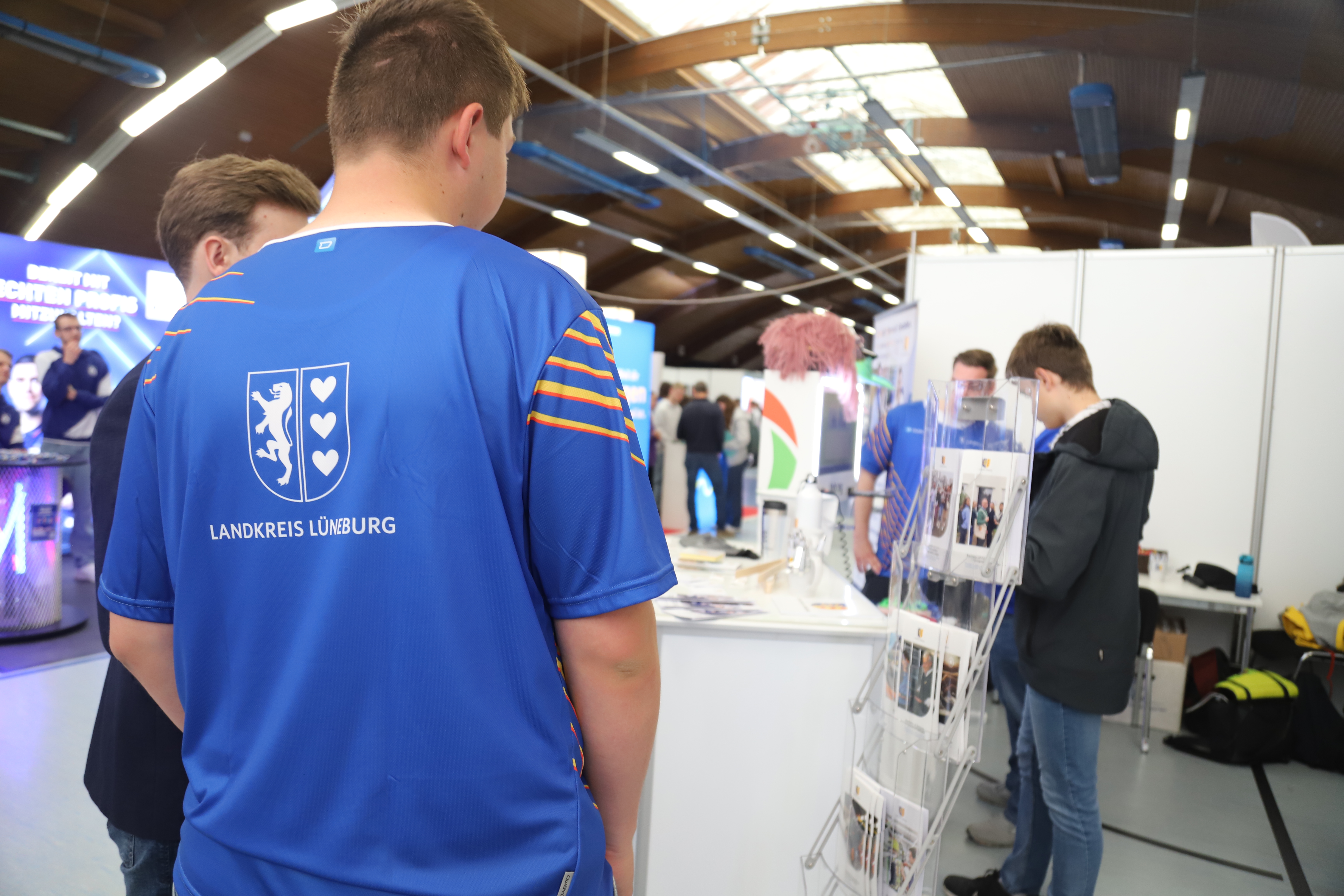 Menschen auf einer Messe vor dem Stand des Landkreises Lüneburg