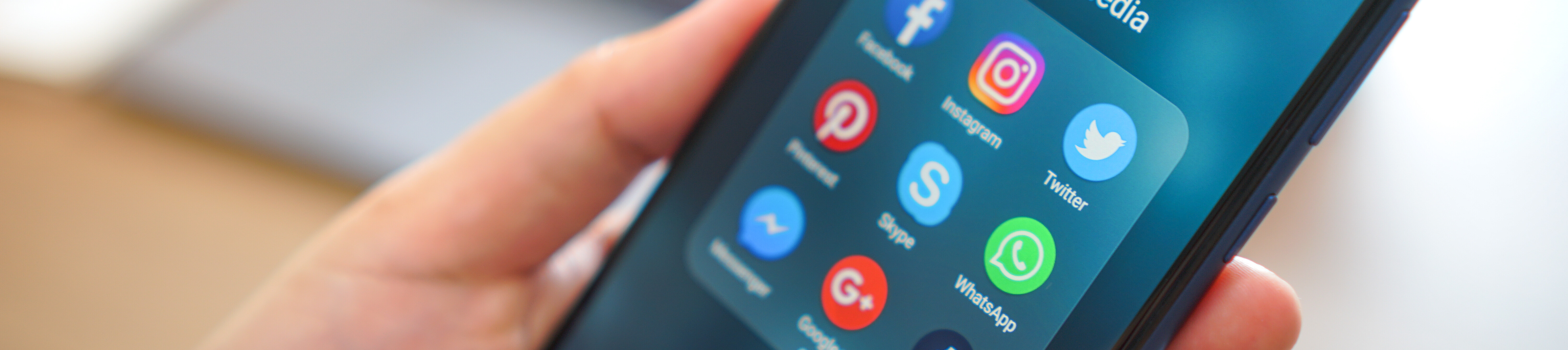 Mehrere Icons auf einem Display zeigen Social Media Plattformen nebeneinander: Whatsapp, Twitter und Facebook.