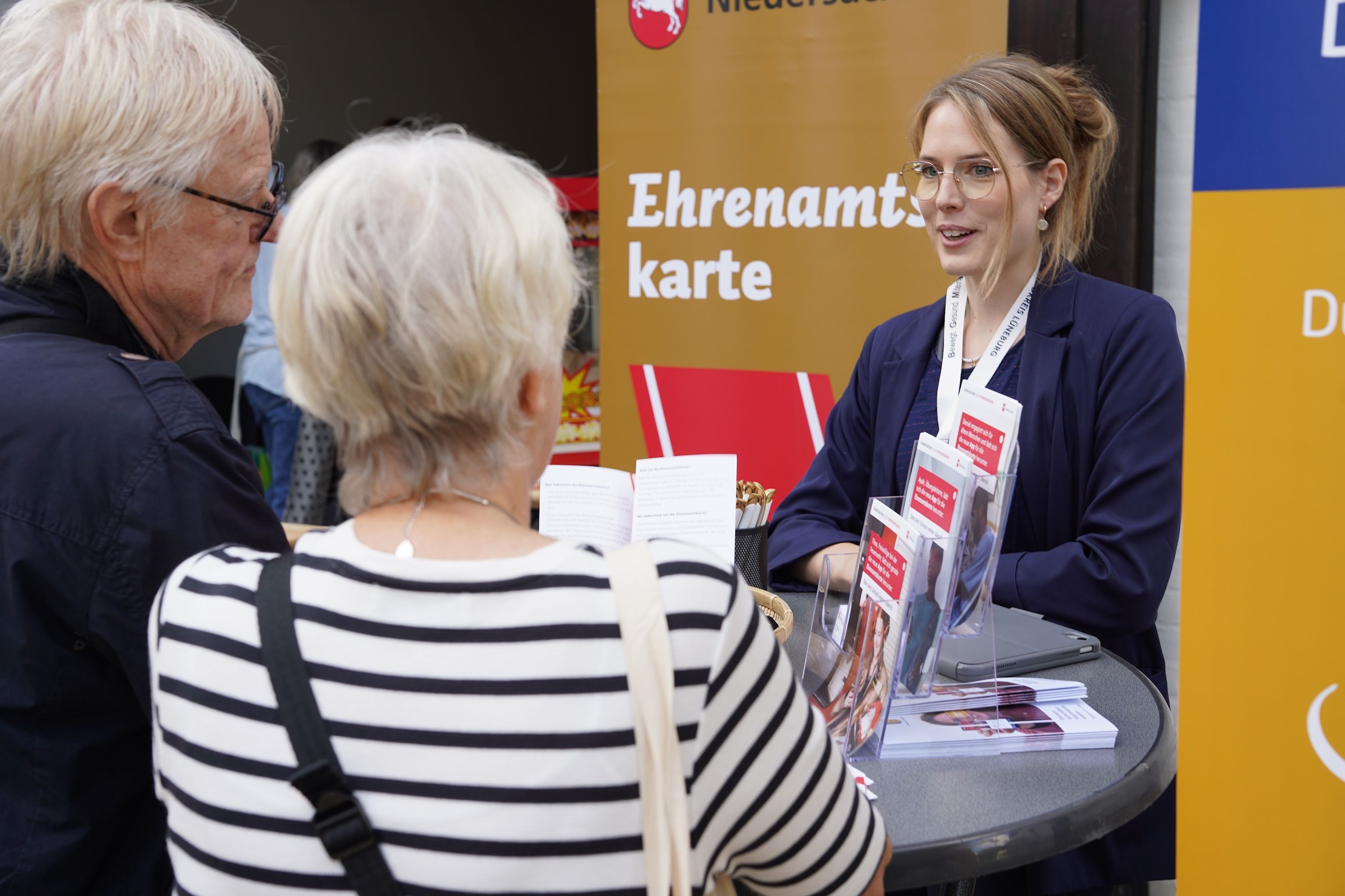 Corinna Wicke berät zwei Menschen zur Ehrenamtskarte im Landkreis Lüneburg