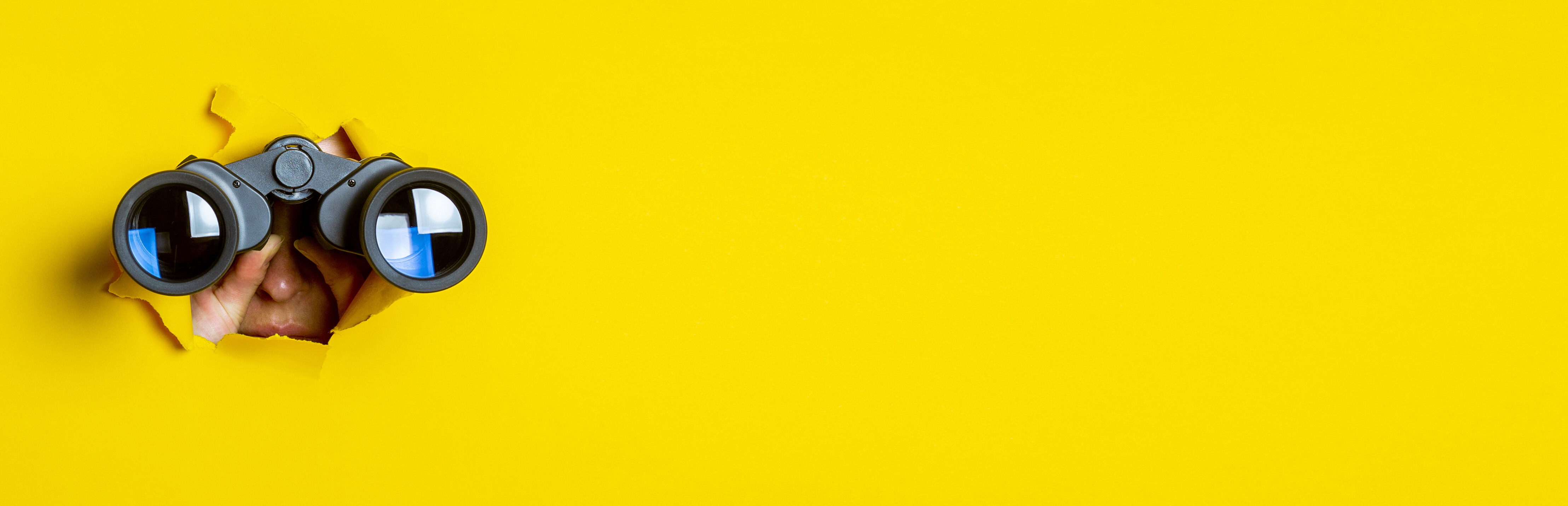 Fernglas vor gelbem Hintergrund