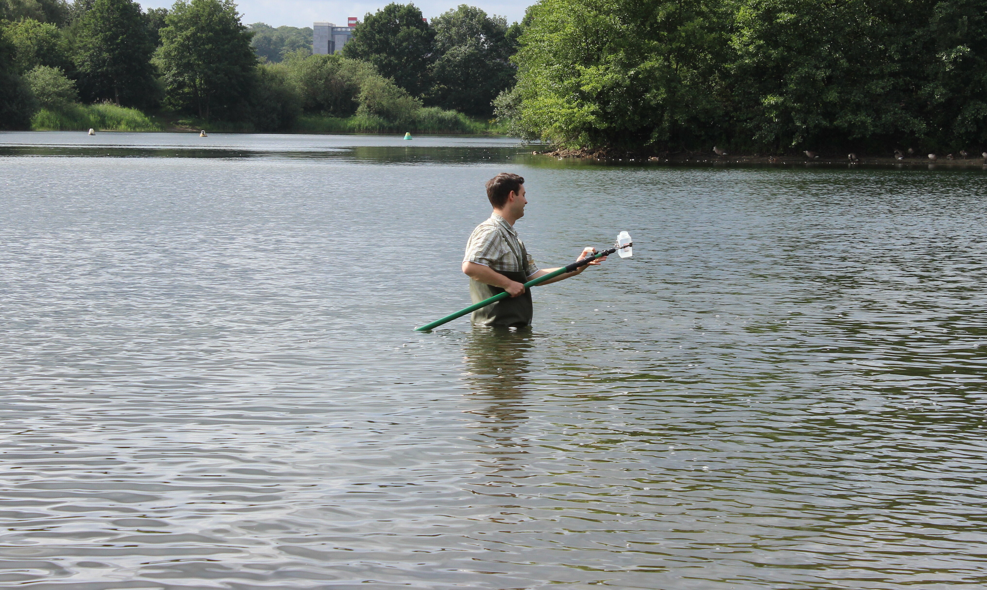 Untersuchung eines Badesees durch einen Mitarbeiter des Gesundheitsamts