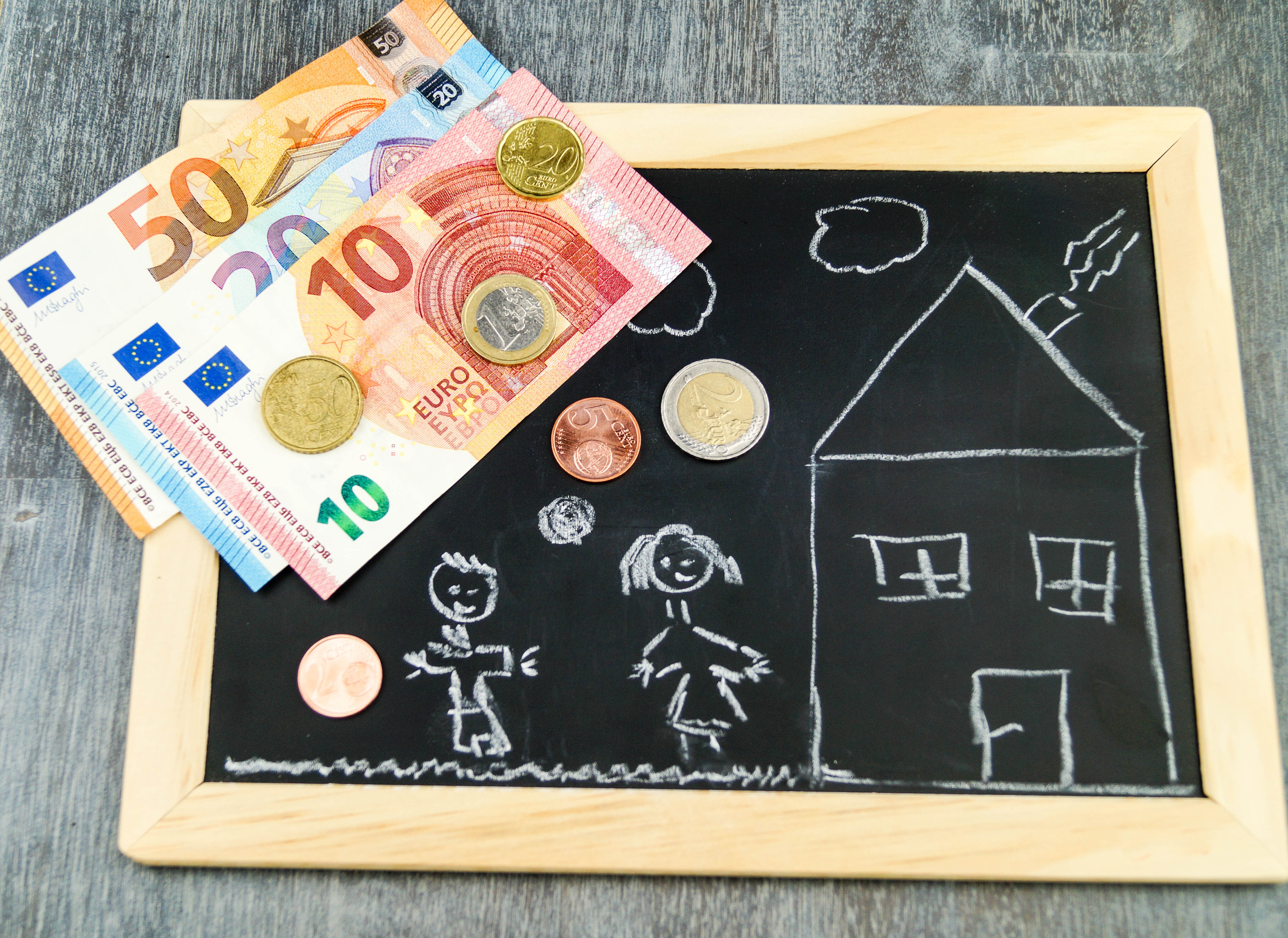 Ein Haus mit Geldscheinen daneben.